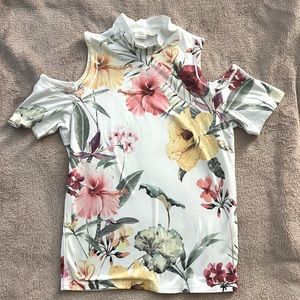 Floral short sleeved turtleneck with cutout shoulders.